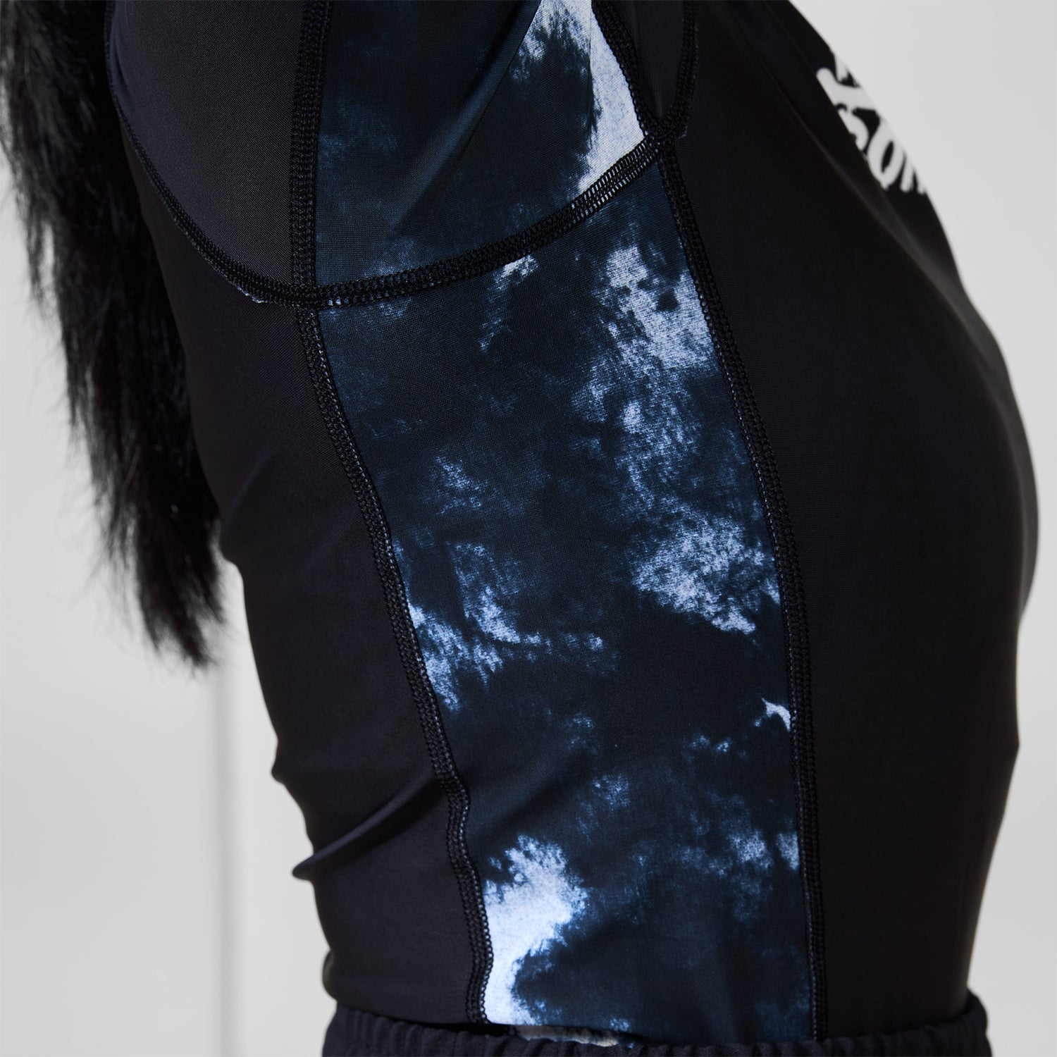 Close-up of gray marble-style side panel and stitching on the Women’s Ash BJJ Rash Guard.