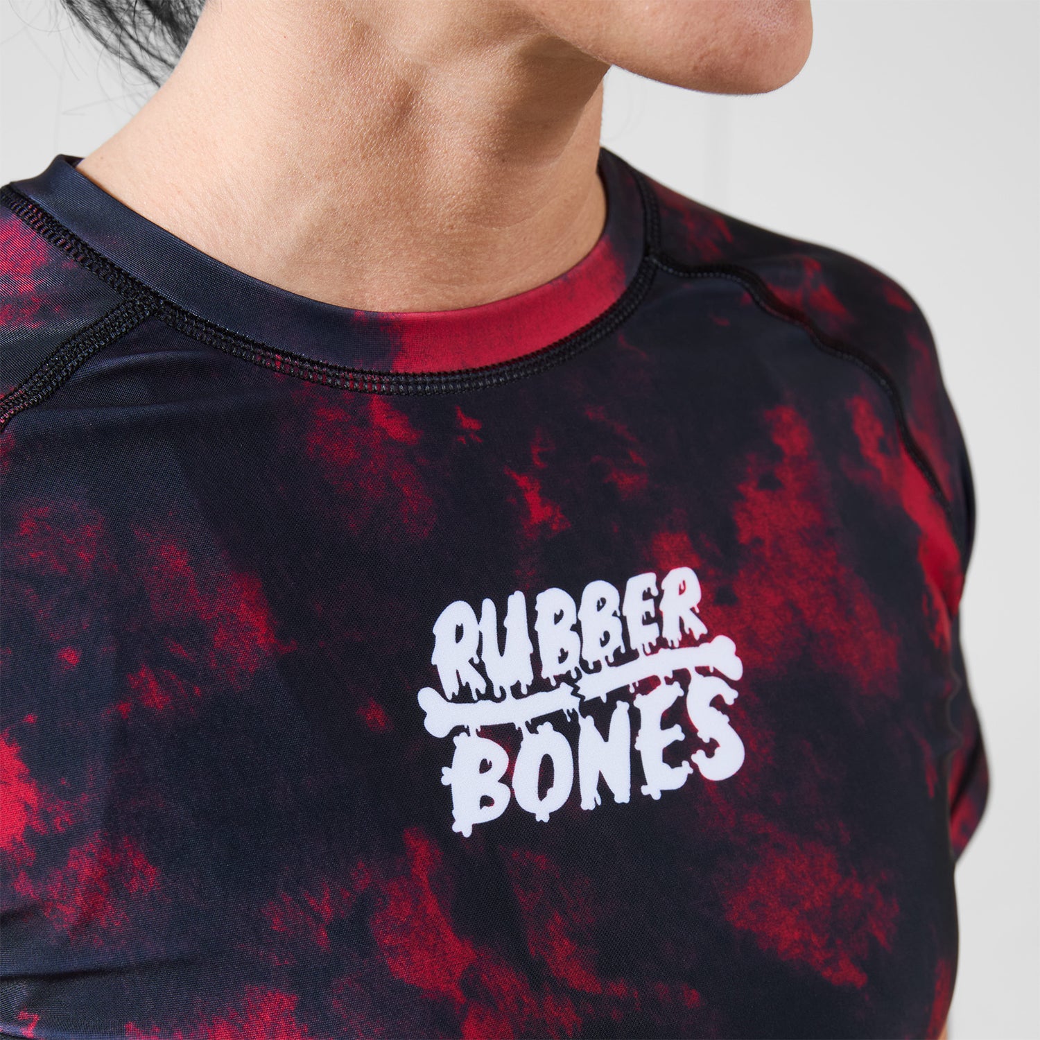 Close-up of white Rubber Bones logo printed on the chest of the Women’s Ember BJJ Rash Guard.