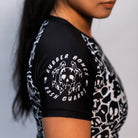 Close-up of the Rubber Bones Ranked Black rash guard sleeve – Melting skull logo with 'Rubber Bones Rash Guards' text on a black background.