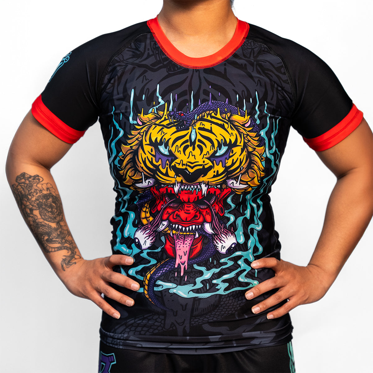 Front view of the Rubber Bones Tora Oni women's rash guard – Black rash guard with a detailed tiger-demon illustration, red sleeve cuffs, and a form-fitting athletic cut.