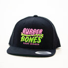 Product shot of OG Snapback Hat featuring bold Rubber Bones skull design with flat visor.